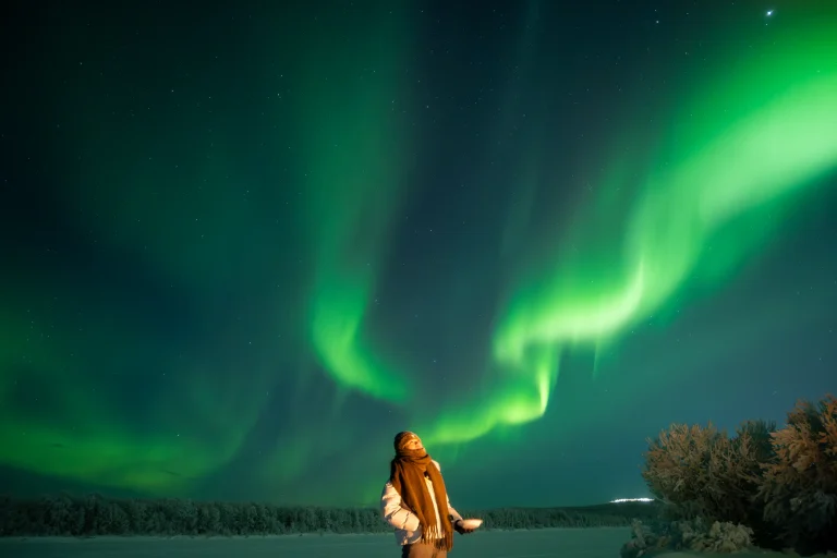 Northern Lights over Finnish Lapland near Rovaniemi, Arctic sky glowing above snowy landscape